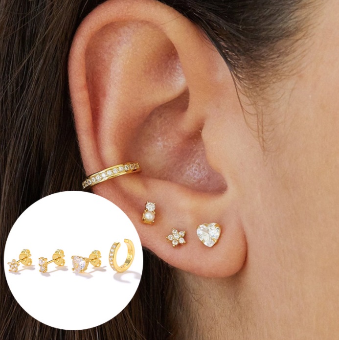 A model's ear adorned with various styles from the 18k gold stud earrings set.