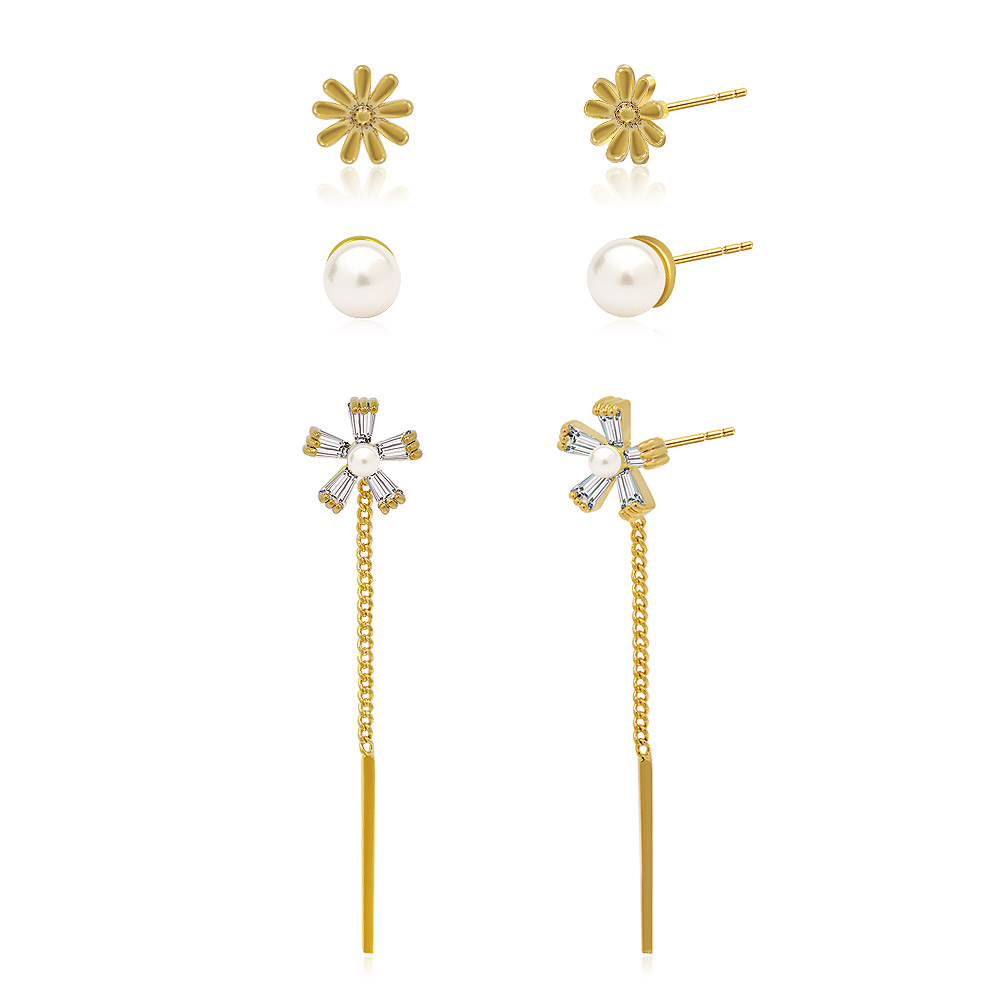 Close-up of gold flower earrings with pearl and gemstone