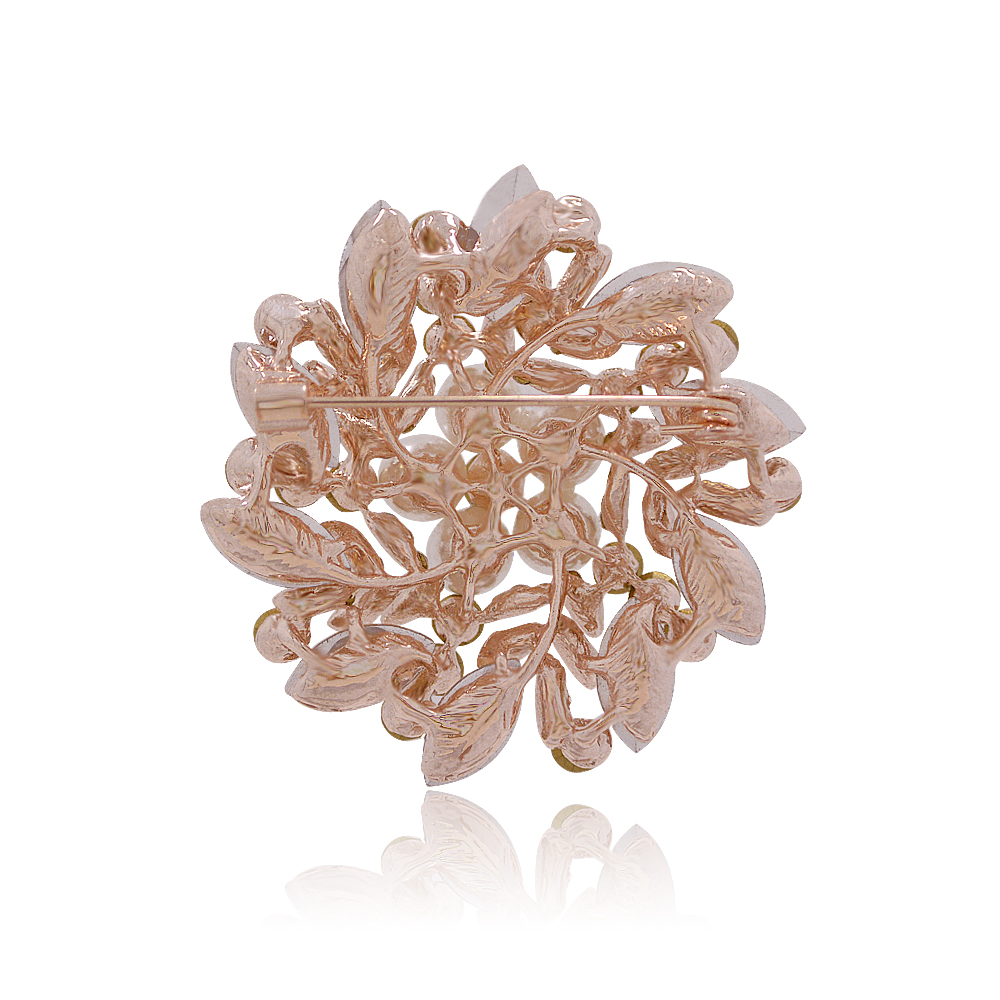 Detailed view of the gold-plated frame and crystal setting on the floral brooch.